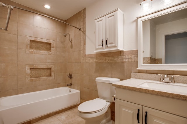 full bathroom with toilet, tiled shower / bath, tile walls, vanity, and tile patterned flooring