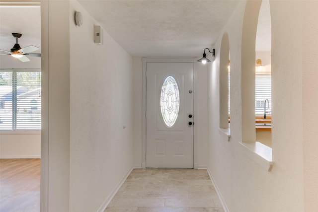 entryway with sink, a textured ceiling, and ceiling fan