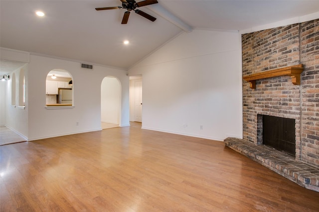 unfurnished living room featuring light hardwood / wood-style flooring, vaulted ceiling with beams, a fireplace, and ceiling fan