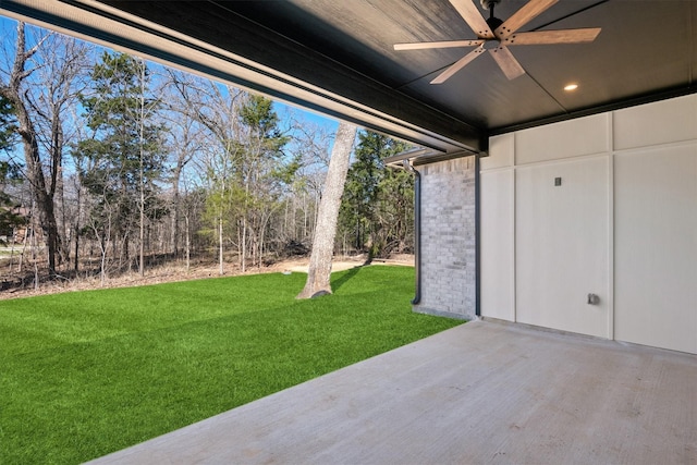 view of yard featuring ceiling fan and a patio