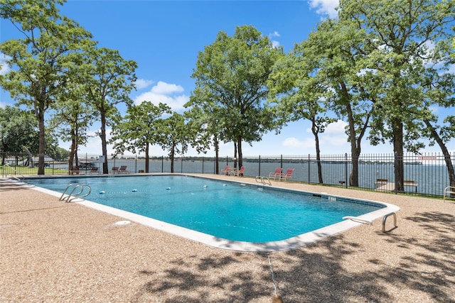 view of swimming pool featuring a water view and a patio