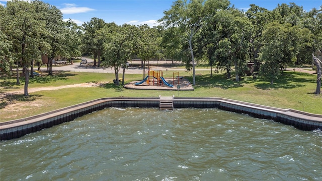 view of dock featuring a playground, a water view, and a lawn