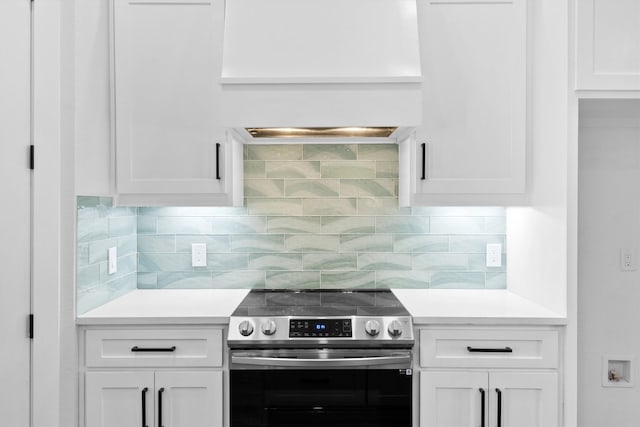 kitchen with white cabinetry, decorative backsplash, and stainless steel range with electric stovetop