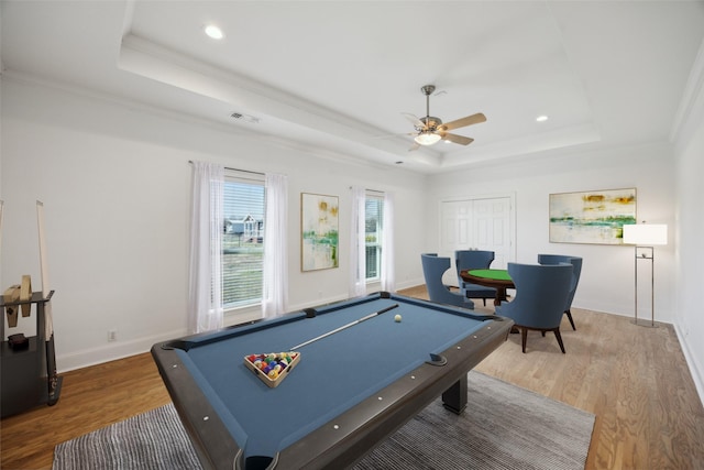 rec room with crown molding, hardwood / wood-style flooring, billiards, ceiling fan, and a tray ceiling