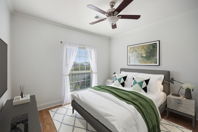 bedroom with wood-type flooring, ornamental molding, and ceiling fan