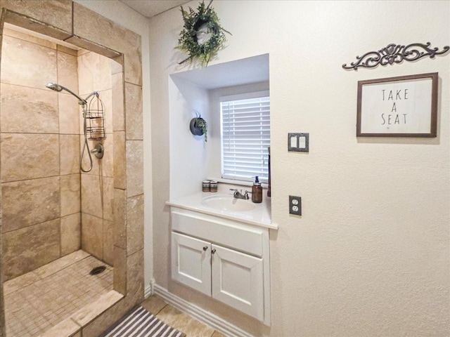 bathroom featuring vanity, tile patterned floors, and tiled shower