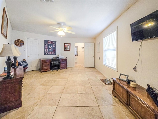 home office with light tile patterned floors and ceiling fan