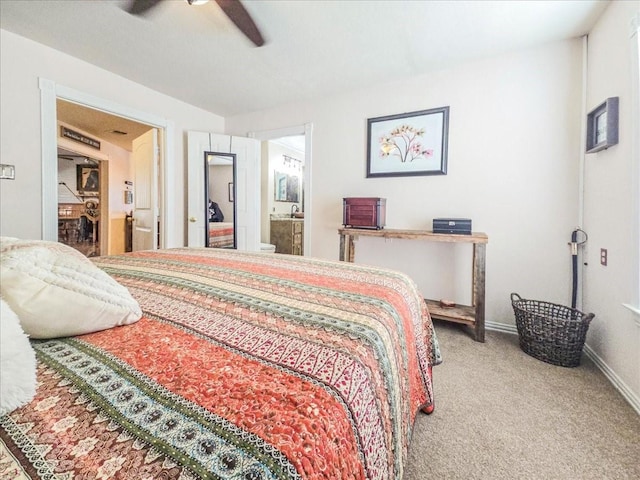 bedroom with ceiling fan, ensuite bath, and carpet floors