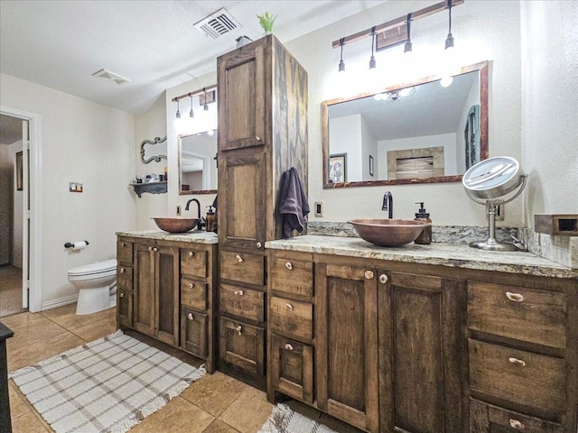 bathroom featuring tile patterned flooring, vanity, and toilet