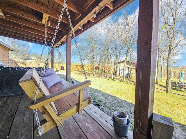 wooden deck with an outdoor structure and a lawn