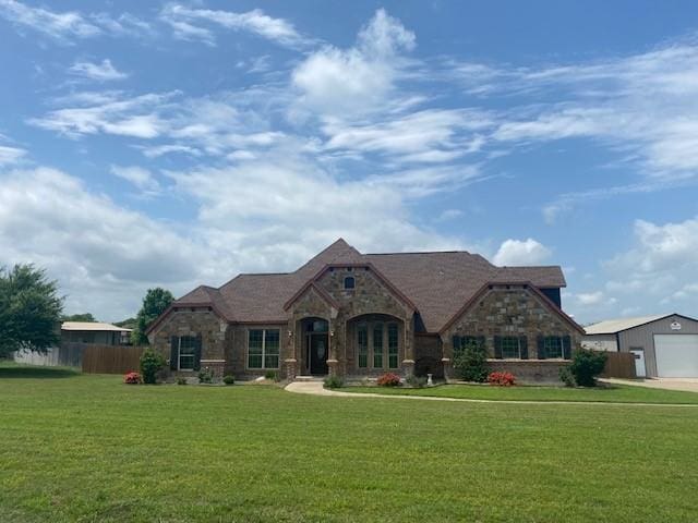 166 Cactus Dr, Decatur, TX 76234 - french country style house featuring a garage, fence, a front yard, and stone siding
