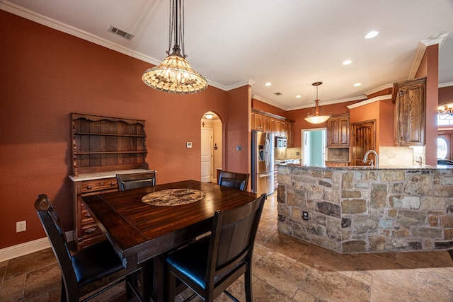 166 Cactus Dr, Decatur, TX 76234 - dining area with crown molding, arched walkways, stone tile floors, recessed lighting, and visible vents