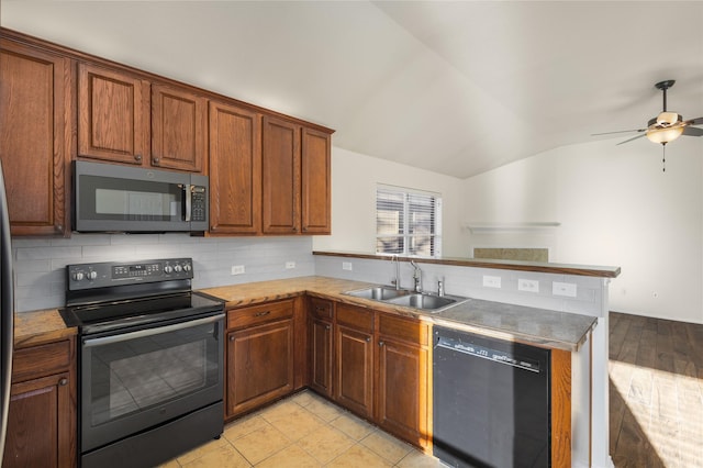 kitchen featuring vaulted ceiling, sink, kitchen peninsula, and black appliances