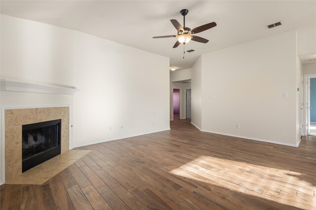 unfurnished living room featuring dark hardwood / wood-style flooring, ceiling fan, and a fireplace