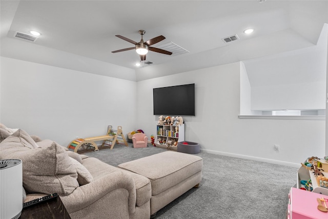 carpeted living room featuring ceiling fan and a tray ceiling