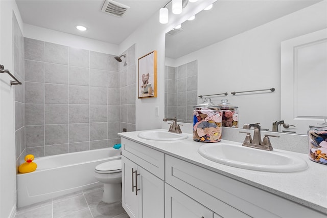 full bathroom with tiled shower / bath, vanity, tile patterned floors, and toilet