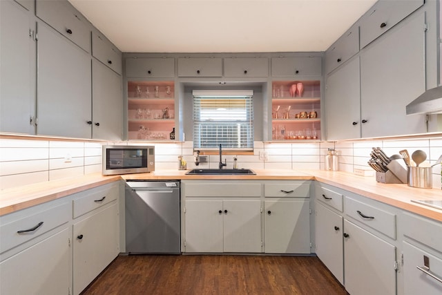 kitchen with sink, backsplash, stainless steel appliances, white cabinets, and dark hardwood / wood-style flooring