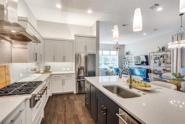 kitchen with pendant lighting, appliances with stainless steel finishes, sink, and extractor fan