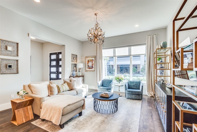 living room with dark wood-type flooring, french doors, and a notable chandelier