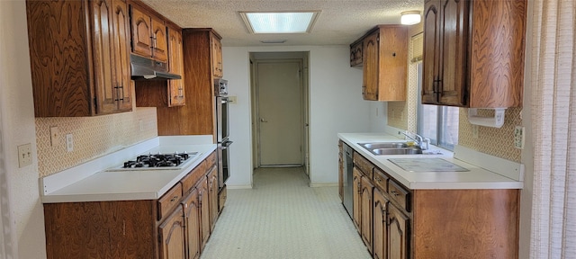 kitchen with sink, double oven, backsplash, a textured ceiling, and white gas cooktop