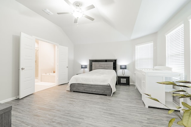 bedroom featuring light hardwood / wood-style flooring, vaulted ceiling, ceiling fan, and ensuite bathroom