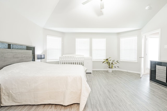 bedroom with ceiling fan, vaulted ceiling, and light wood-type flooring