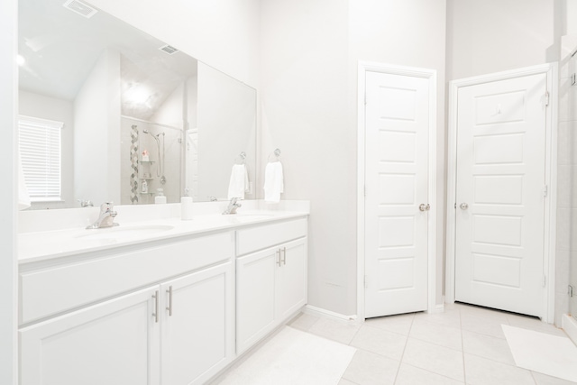 bathroom featuring a shower with door, vanity, and tile patterned floors