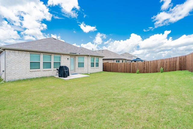 rear view of house with a patio and a yard