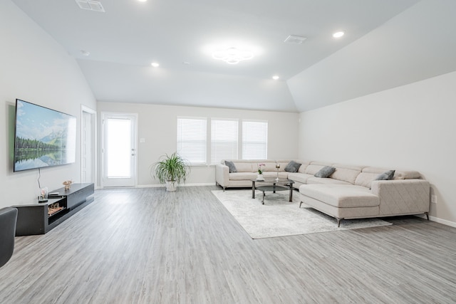 living room featuring light hardwood / wood-style flooring and vaulted ceiling