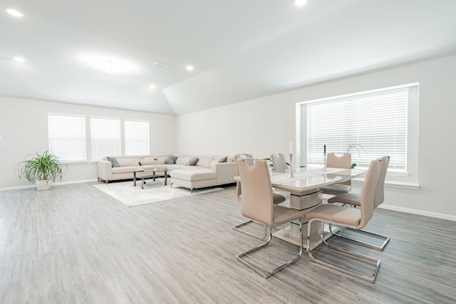 dining space featuring vaulted ceiling and hardwood / wood-style floors