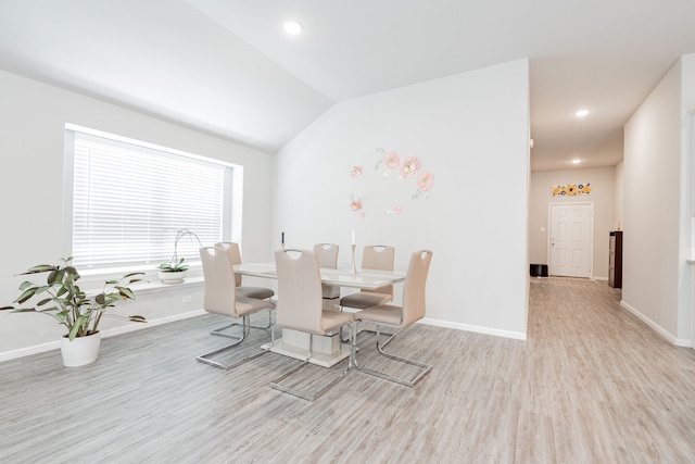 unfurnished dining area with lofted ceiling and light wood-type flooring