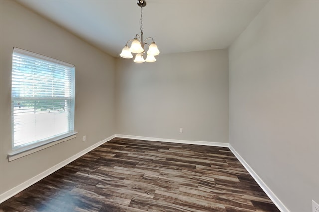 empty room with an inviting chandelier and dark hardwood / wood-style flooring