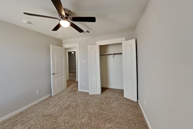 unfurnished bedroom featuring light colored carpet, a closet, and ceiling fan