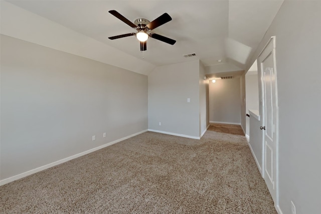 carpeted empty room with vaulted ceiling and ceiling fan