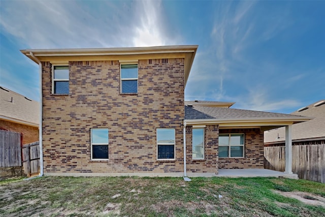 rear view of house featuring a patio and a yard