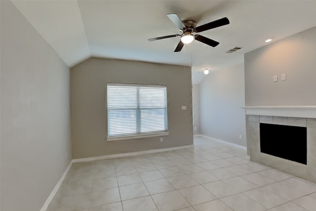 unfurnished living room with light tile patterned floors, vaulted ceiling, a tile fireplace, and ceiling fan