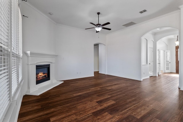 unfurnished living room featuring crown molding, dark wood-type flooring, and ceiling fan