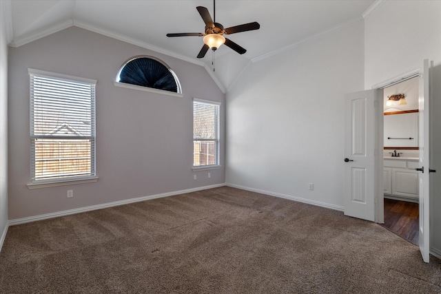 empty room featuring crown molding, ceiling fan, vaulted ceiling, and dark colored carpet