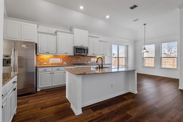 kitchen featuring pendant lighting, sink, stainless steel appliances, white cabinets, and a center island with sink