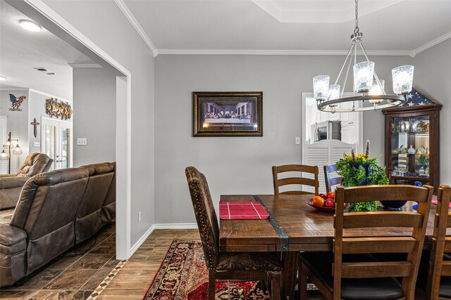 dining room featuring crown molding, dark hardwood / wood-style floors, and an inviting chandelier