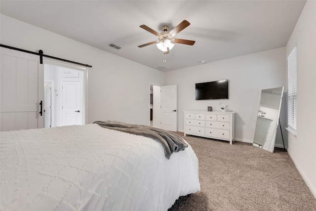 carpeted bedroom featuring ceiling fan and a barn door