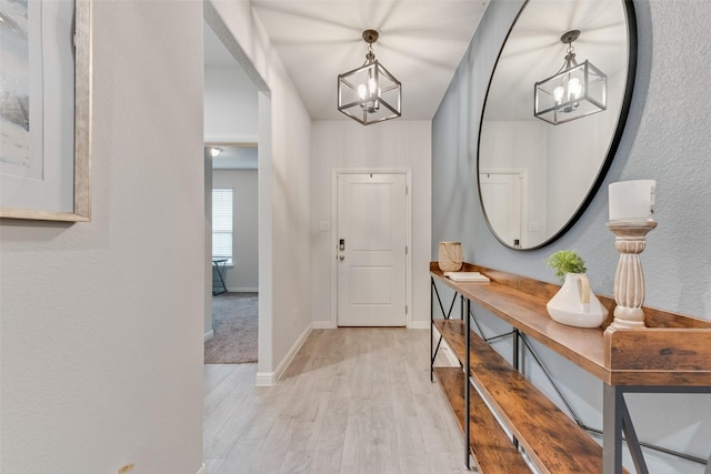 foyer with an inviting chandelier and light hardwood / wood-style flooring