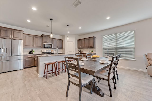 dining room with sink and light wood-type flooring