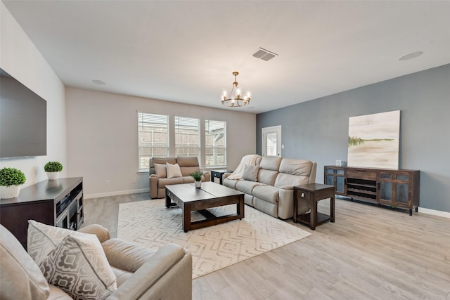 living room featuring an inviting chandelier and light wood-type flooring