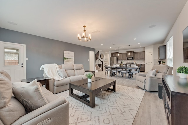 living room with light hardwood / wood-style flooring and a notable chandelier