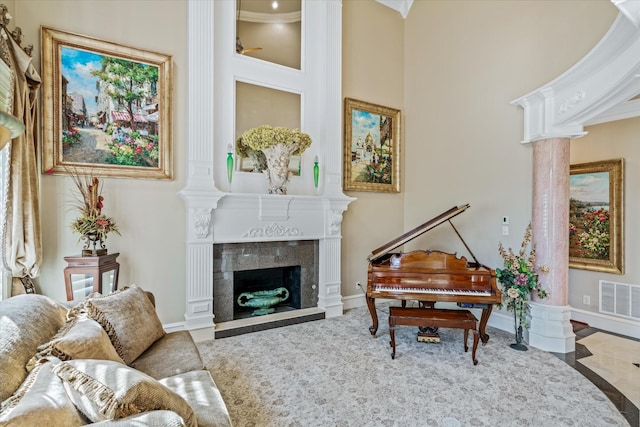 sitting room with ornate columns, ornamental molding, and a high end fireplace