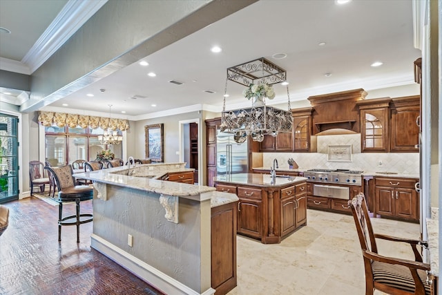 kitchen featuring a spacious island, a breakfast bar area, decorative light fixtures, stainless steel appliances, and backsplash