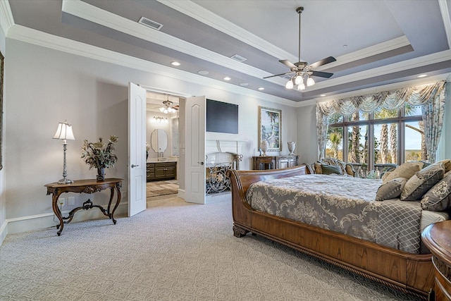 bedroom featuring ornamental molding, a raised ceiling, ceiling fan, and ensuite bathroom