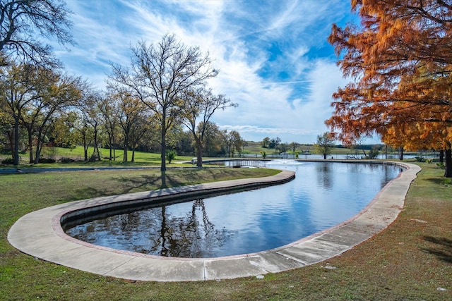 view of swimming pool featuring a water view and a yard