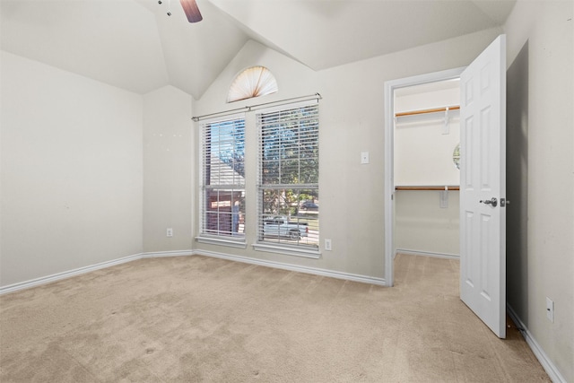 carpeted spare room with vaulted ceiling and ceiling fan